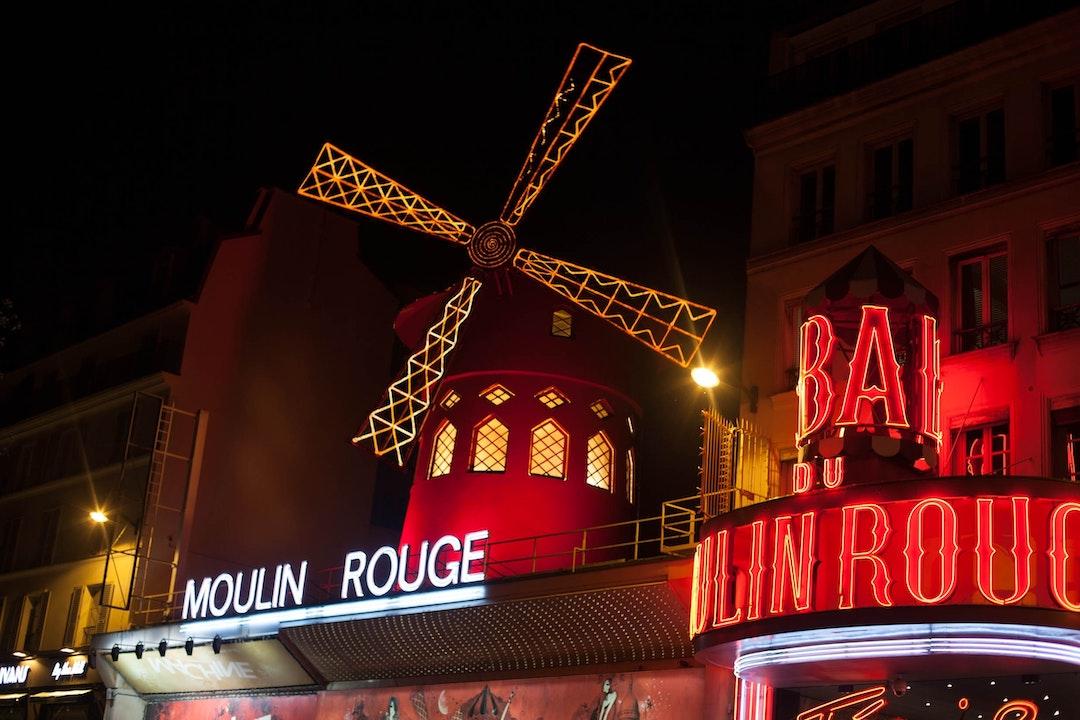 Moulin au dessus du Moulin Rouge de nuit